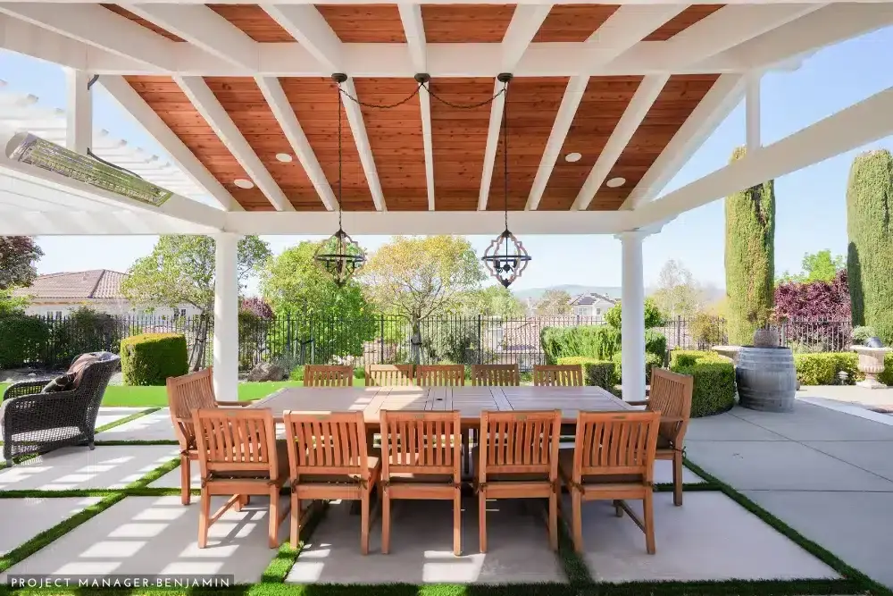 Bright outdoor living area with stone fireplace and seating for a stylish home addition